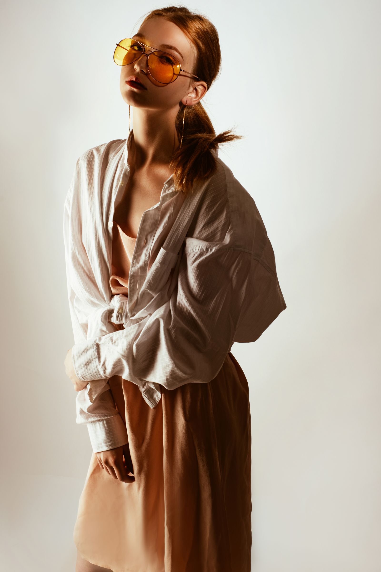 Look éditorial : chemise blanche nouée sur une robe pêche